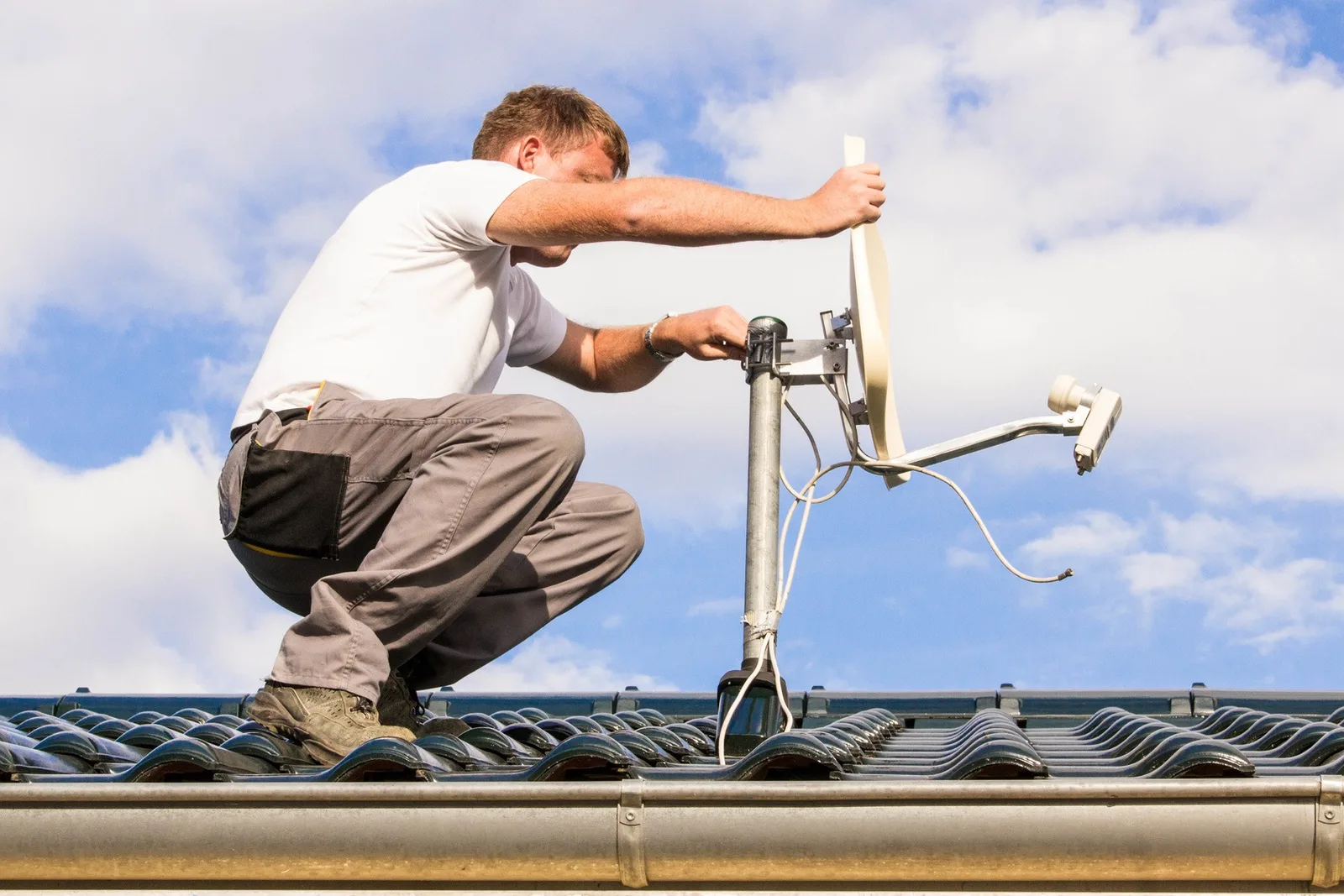 Installation d'une parabole satellite par un technicien TVP